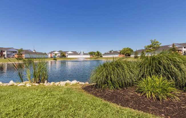 This is a photo of a pond with a fountain and building exteriors at Washington Place Apartments in Miamisburg, Ohio in Washington Township.