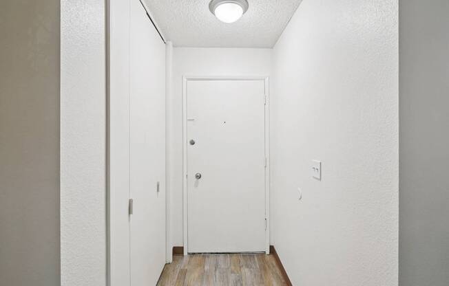 A white door is in the middle of a hallway.