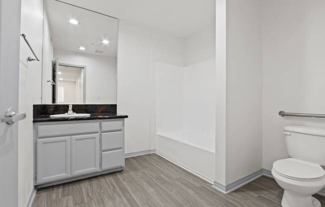 a bathroom with a toilet sink and shower and a mirror