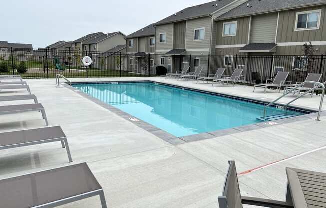 Sparkling blue pool surrounded by lounge chairs.