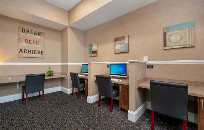 A room with a quote on the wall and several computers.