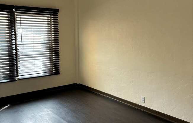 an empty room with a window and a ceiling fan