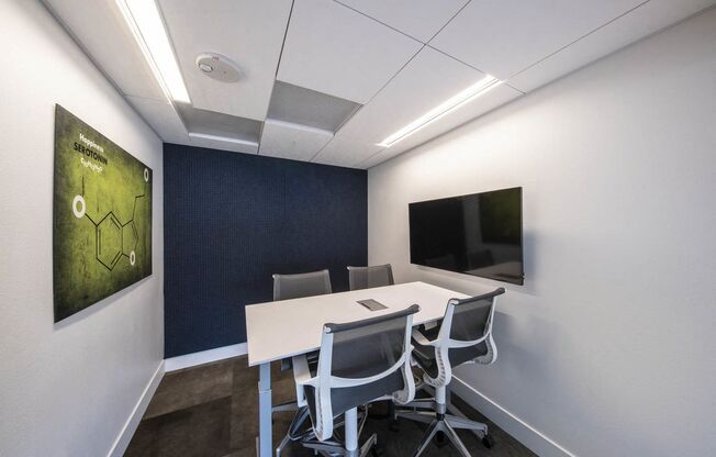 coworking space with a white table and chairs and a television