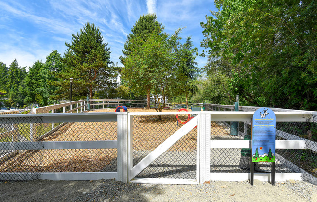 a white fence with a white gate and a blue sign on the side of the fence