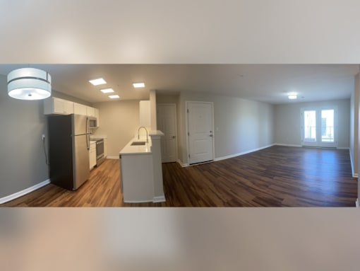 a view of an empty living room with a kitchen