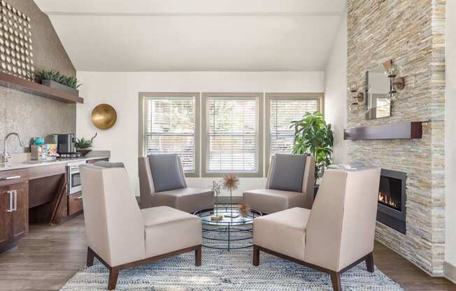a living room with chairs and a table and a fireplace at Arcadia Apartments, Centennial