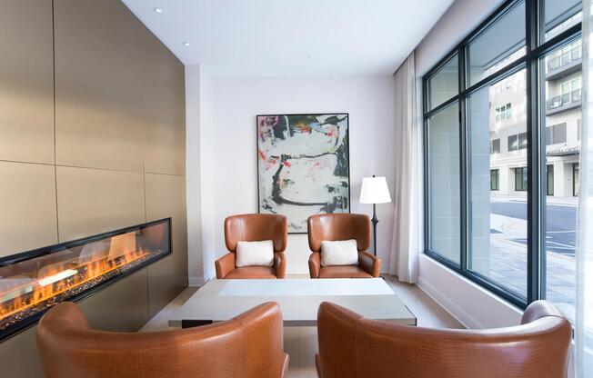 A cozy lounge at Modera Liberty Row features a modern fireplace, comfortable seating, and natural light for relaxed moments throughout the day.