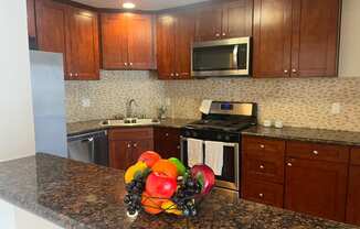 a kitchen with wooden cabinets and granite countertops