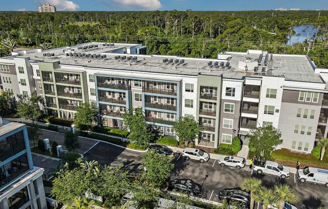 an aerial view of a large apartment building with cars parked outside