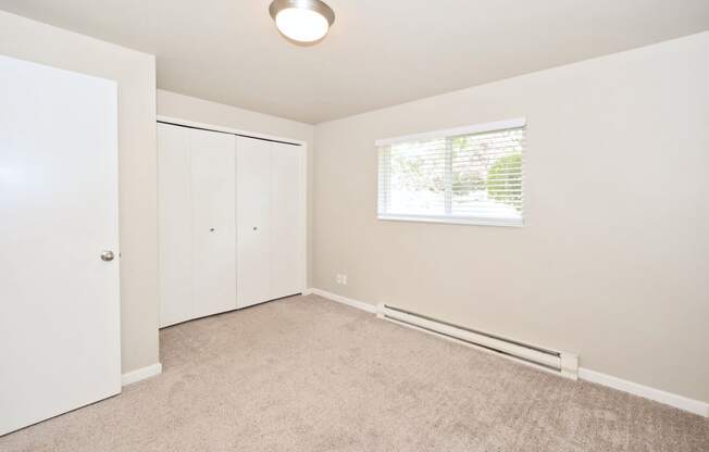 an empty room with white walls and a window