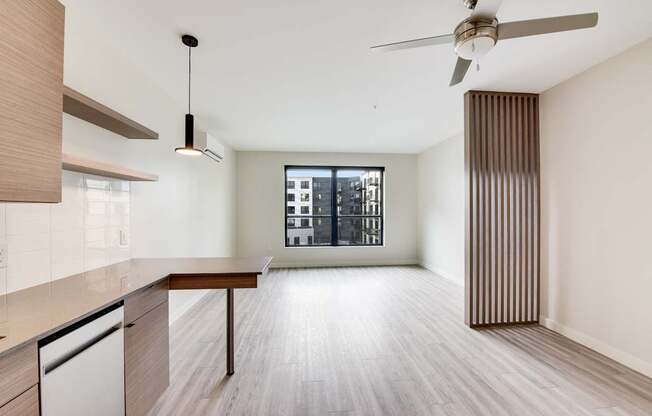 A modern kitchen with a wooden floor and a ceiling fan.