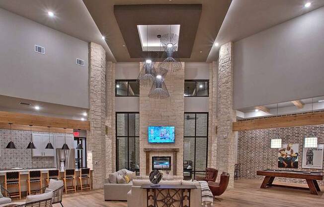 a lobby with a lot of furniture and a tv at Hunters Creek Apartments, Denton, TX 76210