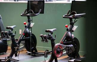 a row of exercise bikes in a room with a green wall