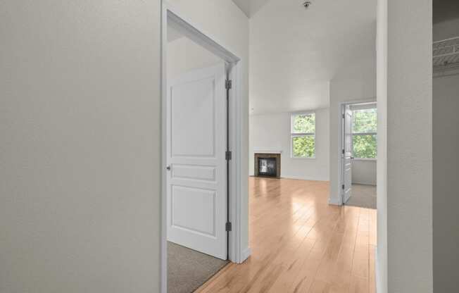 a spacious living room with a white door and a hardwood floor