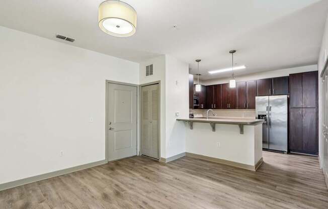 Royal Palm kitchen area with white walls, dark wood cabinets, and a wooden floor at Oakleaf Plantation Apartments in Jacksonville, FL
