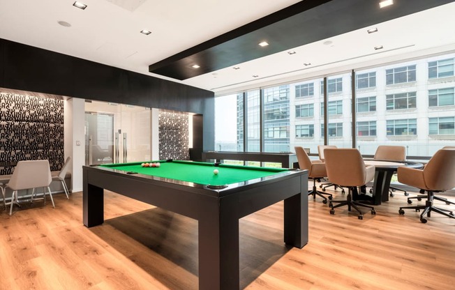 a pool table in a meeting room with chairs and tables