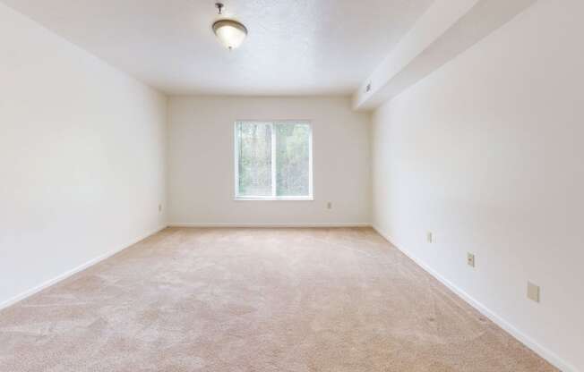 an empty room with white walls and a window