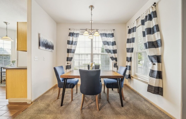 a dining room with a table and chairs and a window