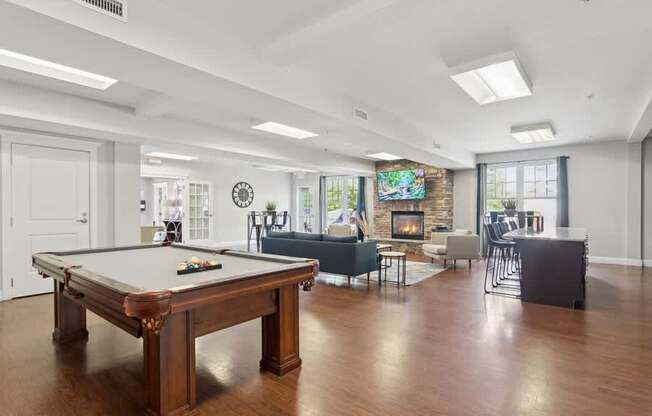 A pool table is in the middle of a room with a fireplace.