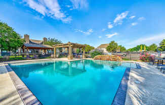 a swimming pool with a gazebo next to a resort style pool