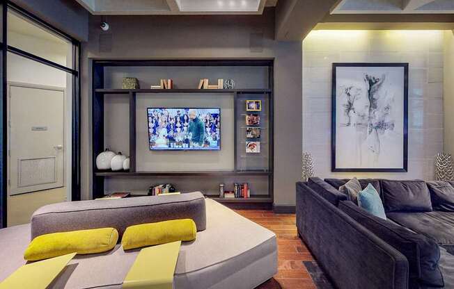 A modern living room with a grey couch and a television.