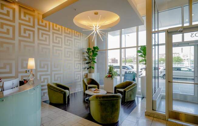 A reception area with a green couch and a white table.