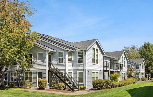 A grey two story house with a black staircase.