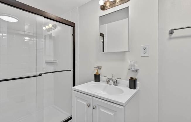 A white bathroom with a sink and mirror.