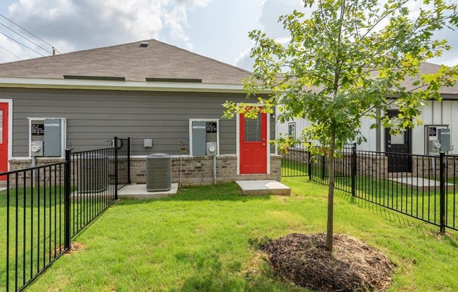 the front of a house with a yard and a tree