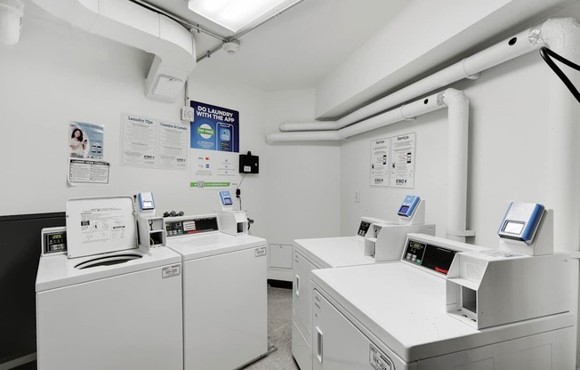 A clean, white-walled room with industrial equipment and pipes.