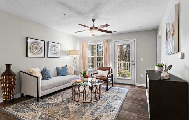A living room with a couch, a coffee table, and a ceiling fan.