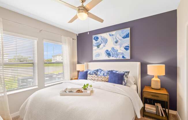 a bedroom with a large bed and a ceiling fan