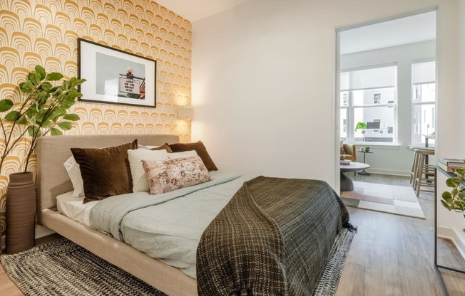 Model bedroom with a bed and a yellow wallpaper