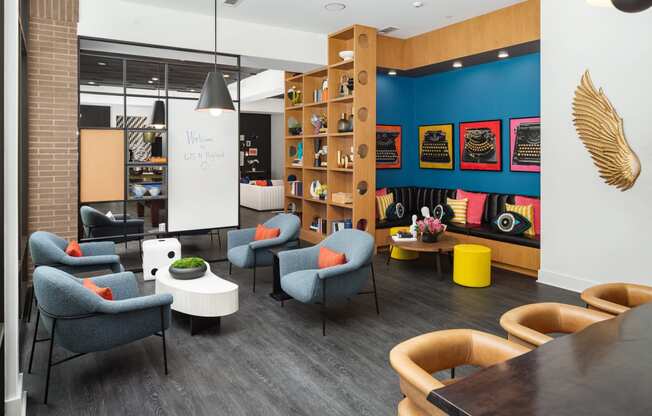 a lounge area with chairs and tables and a whiteboard