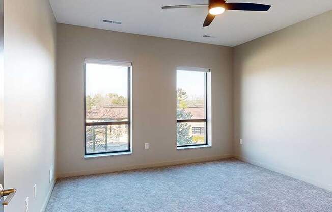 a bedroom with a carpeted floor and two windows