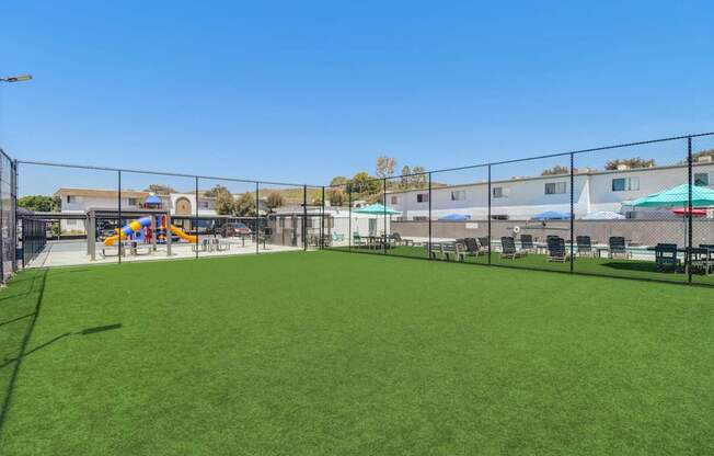 A large green field with a fence surrounding it.