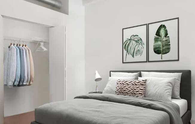A bedroom with a large bed and two framed leaves on the wall.