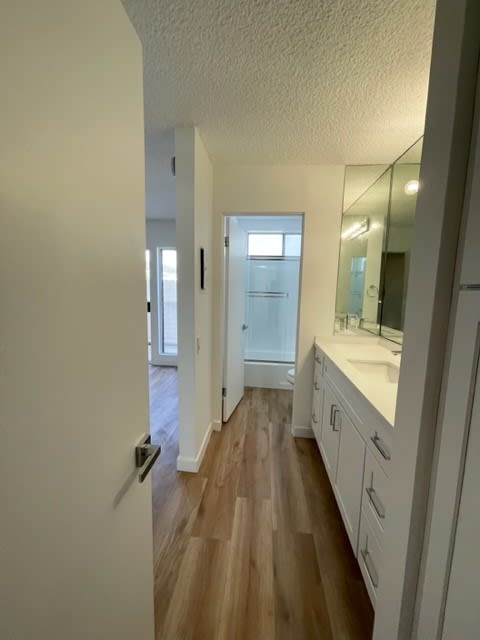 En Suite with Hardwood Floors and White Cabinets