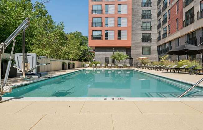 A swimming pool surrounded by buildings and trees.