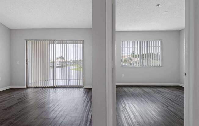an empty living room with wood floors and a sliding glass door