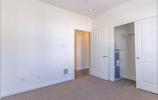 A white room with a door and a small cabinet at Riverplace Apartment Homes, Independence, OR, 97351