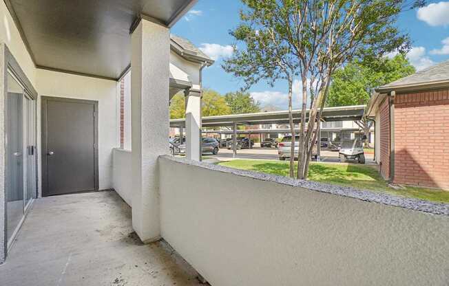A balcony with a tree in the background.