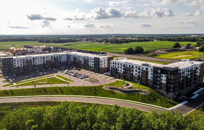 A large apartment complex with a parking lot in front.