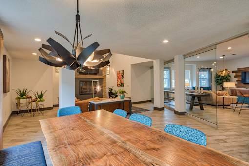 A modern conference room with a long wooden table and blue chairs.