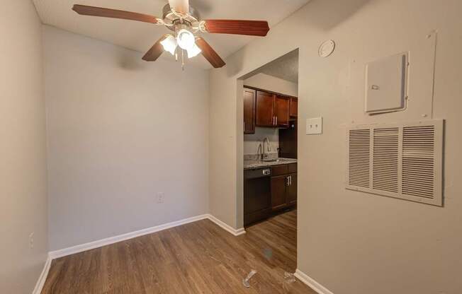 A room with a ceiling fan and a wall-mounted air conditioner unit.