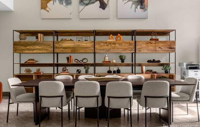 a dining room with a table and chairs in front of a wall with shelves