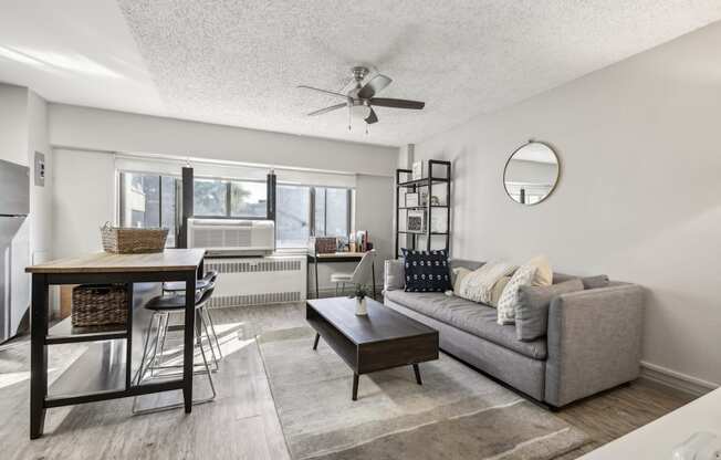 a living room with a couch and a table and a ceiling fan