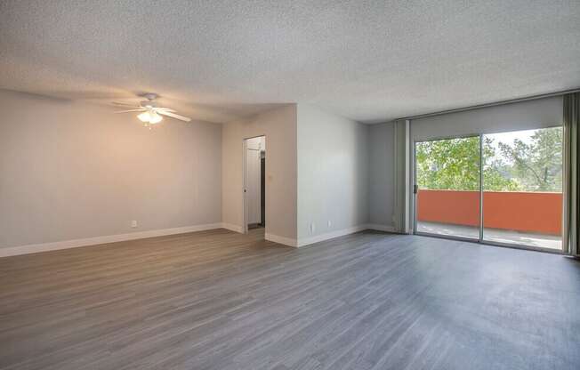 A room with a sliding glass door leading to a balcony.