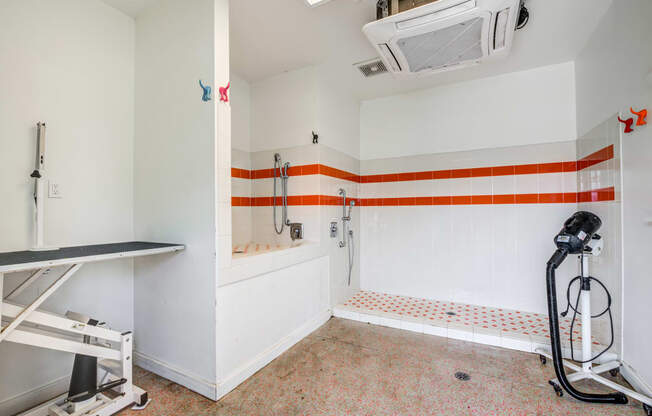 a bathroom with white walls and orange and white stripes on the wall