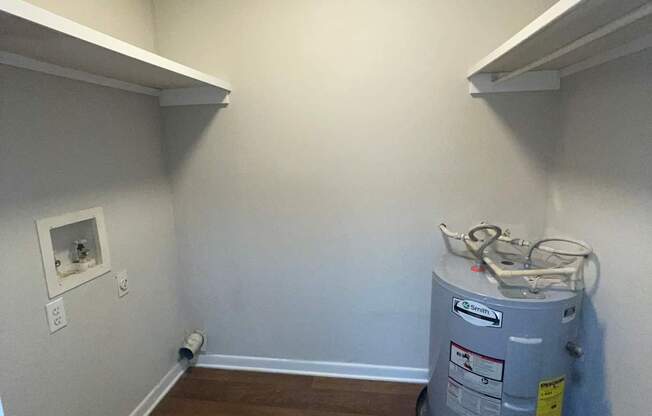 A room with a water heater on the floor.